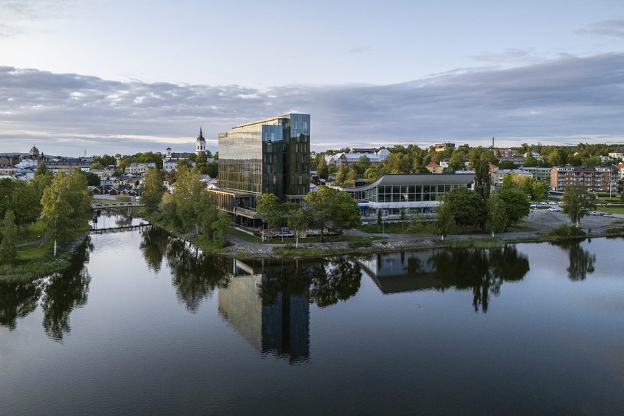 Somrig bild av Hern&ouml; Gin Hotells fasad i kv&auml;llsljus