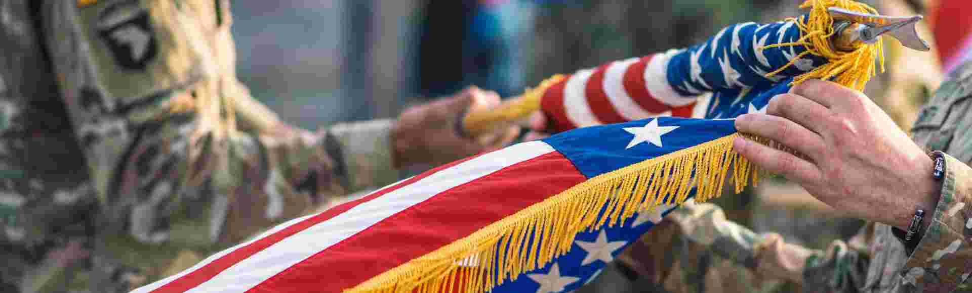 United States Marine Corps soldiers roll up the American flag.