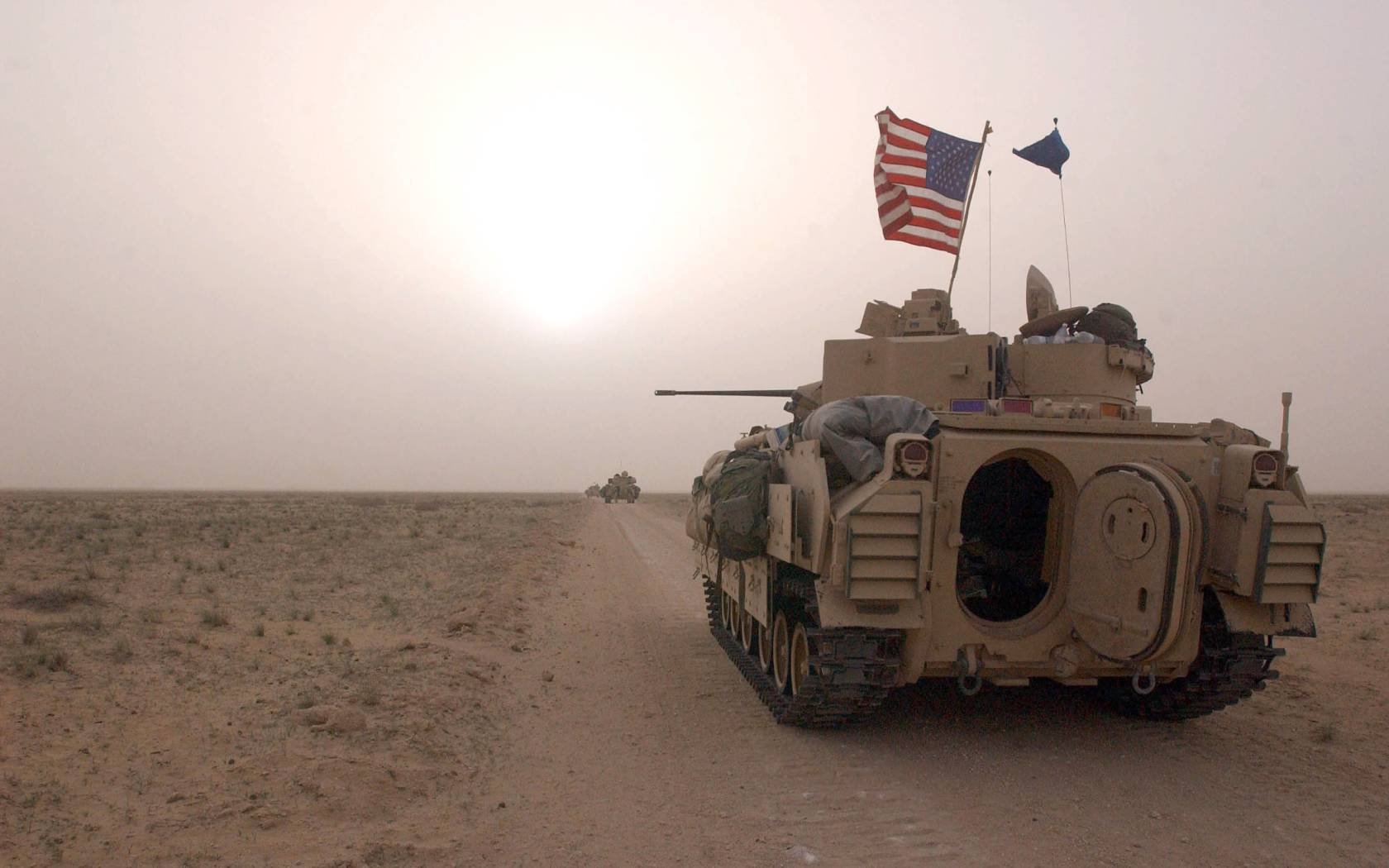 US Army tank drives along a road in Iraq