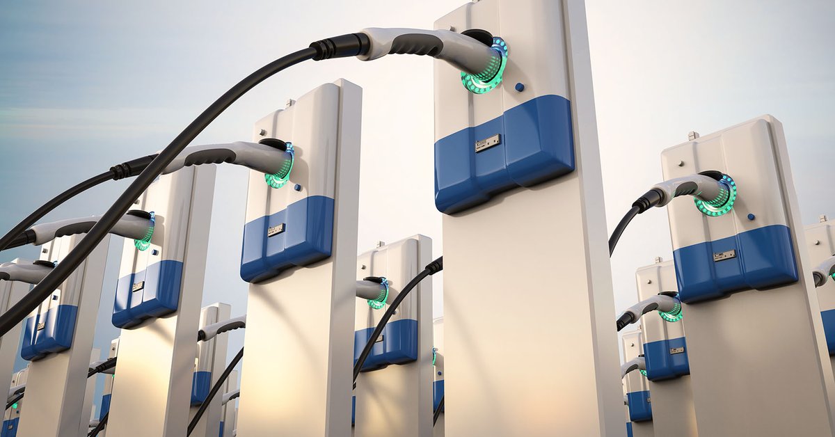 A close-up picture of EV chargers with the sun shining on the blue skies in the background.