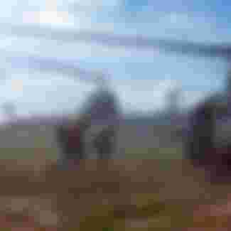 Photograph of American troops running towards a chopper during the Vietnam War.