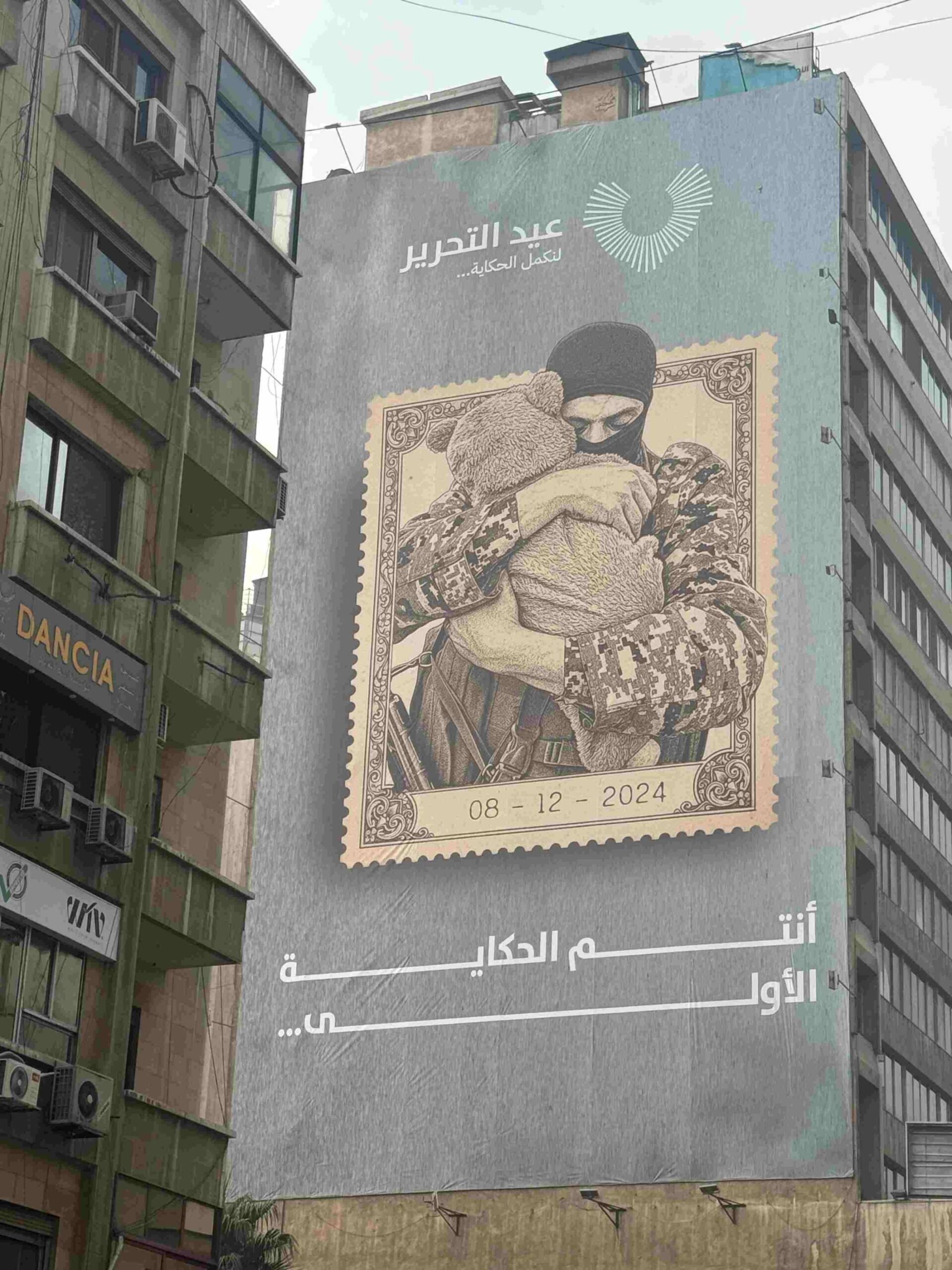 A banner in Damascus commemorates Syria's 'Liberation Day'. The caption reads: 'let’s continue the story…you are the first story.'