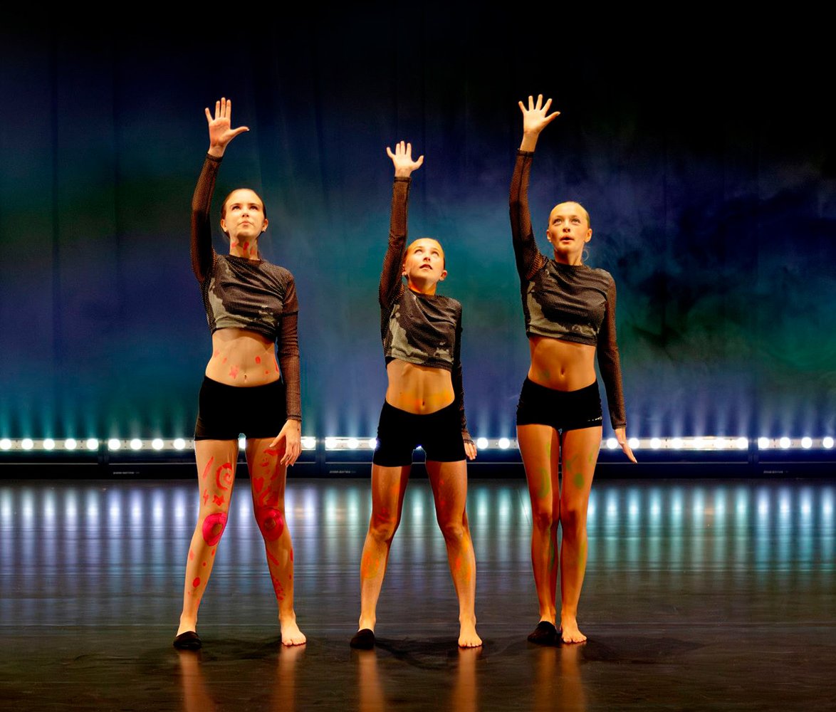 Tre unga dansare på scen.