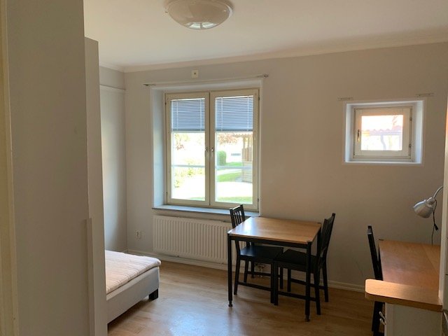 Student room with tabel, chairs, desk and bed.