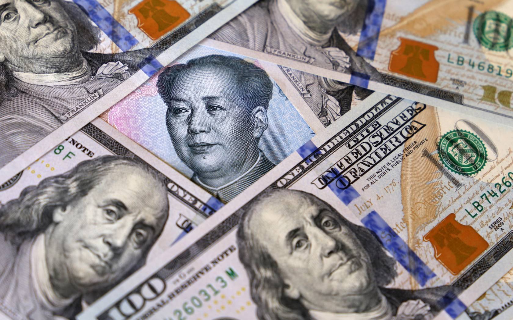 Chinese yuan surrounded by US dollar bills.