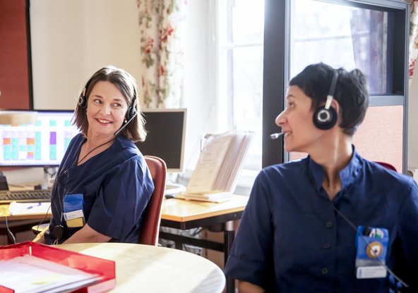 Kvinnliga kollegor samtalar vid skrivbord