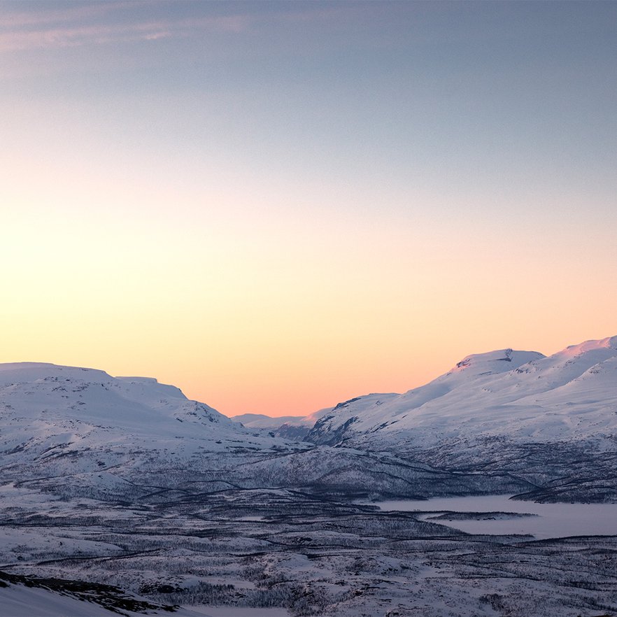 pastellf&auml;rgad himmel ovan fj&auml;lltopparna under slutet av polarnatten
