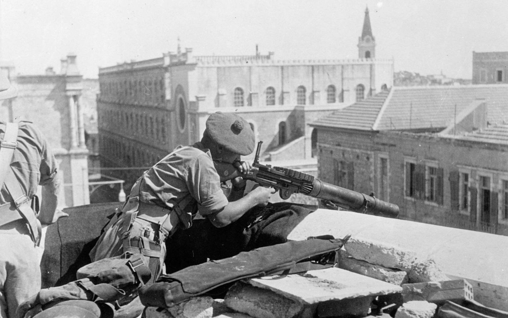 A British soldier manning a Lewis gun on a rooftop in the Old City of Jerusalem, in October 1938.
