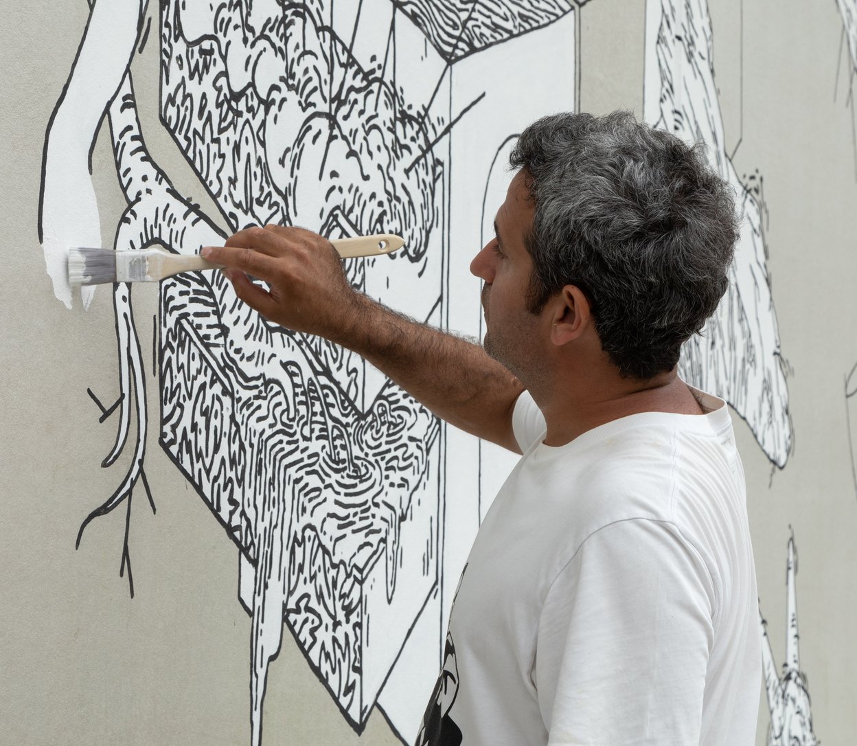 Närbild när Muhammad Ali skapar väggmålningen Under stenen.