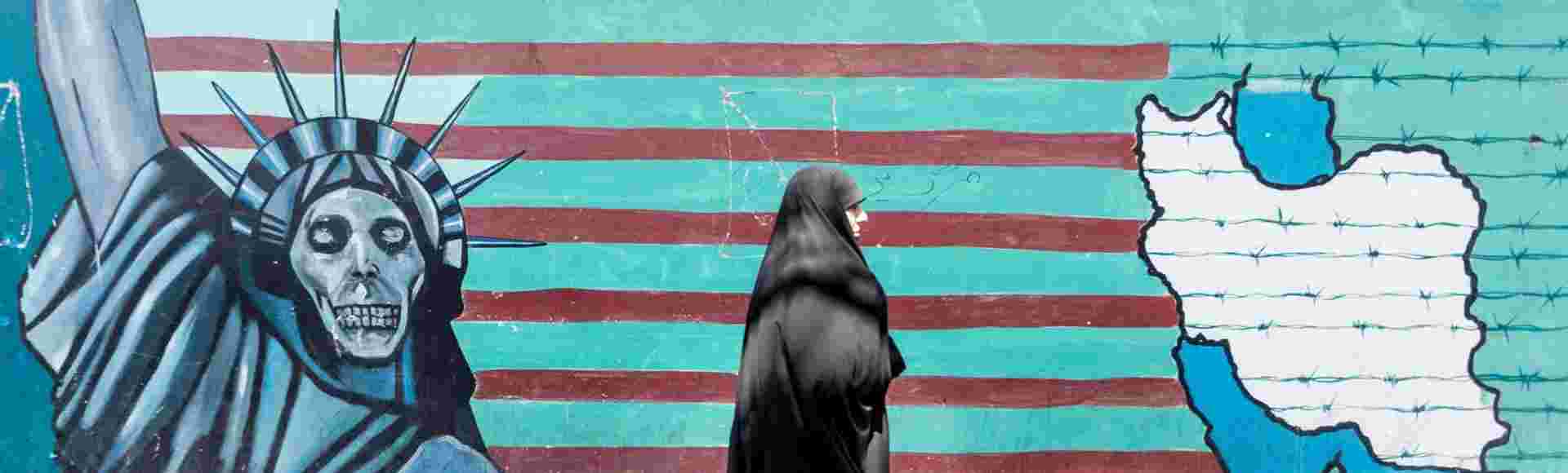 A woman walks in front of anti-American propaganda in Tehran.