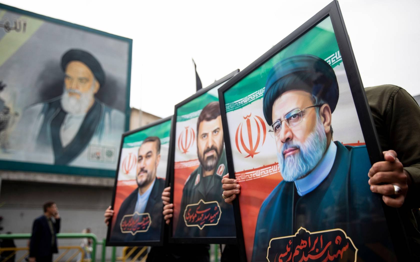 Mourners hold up posters of the late Iranian President Ebrahim Raisi in Tehran, 21 May 2024.