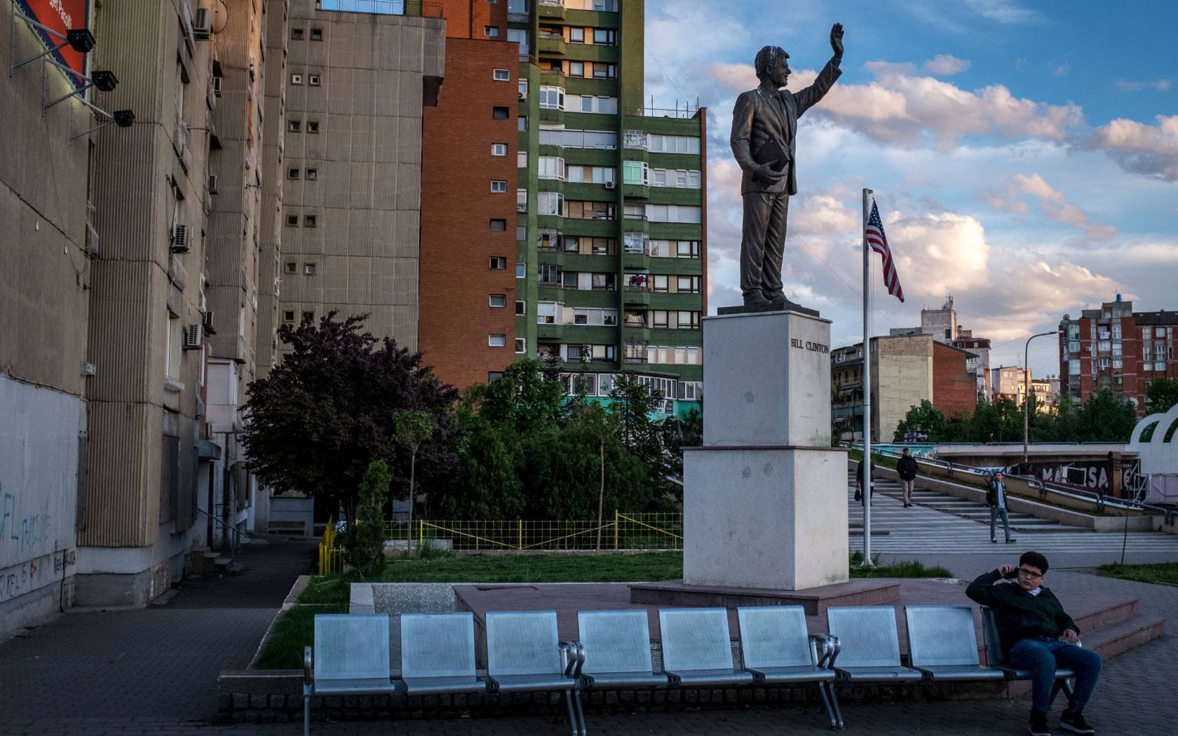 A boy speaks on the phone underneath a 10-foot-high statue of former U.S President Bill Clinton on Bill Clinton Boulevard in 2019 in Pristina, Kosovo.