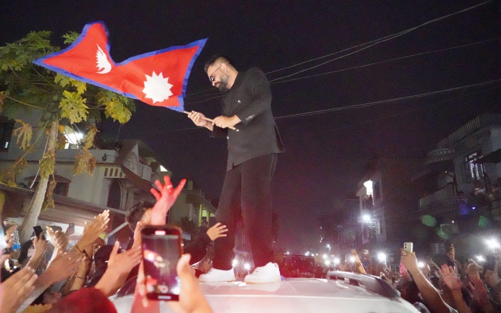 Nepal's new Prime Minister Balendra Shah waves the national flag in Jhapa, Nepal. Credit: ZUMA Press.
