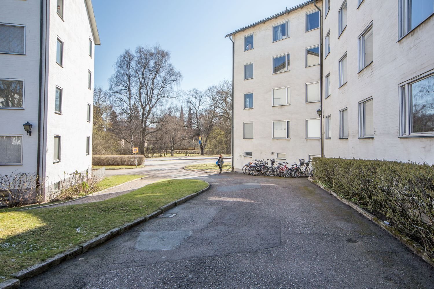 Exterior of white building with bicycle parking outside.