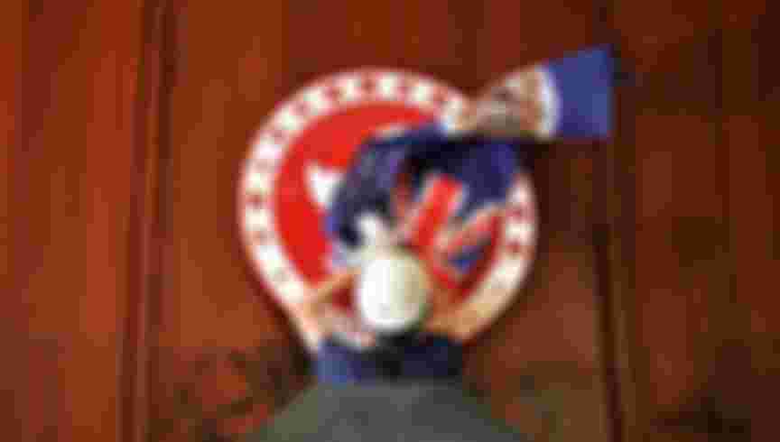 A protester attempts to cover the Hong Kong emblem with a British colonial flag after they broke into the government headquarters in Hong Kong in June 2019, the 22nd anniversary of the city's handover from Britain to China.