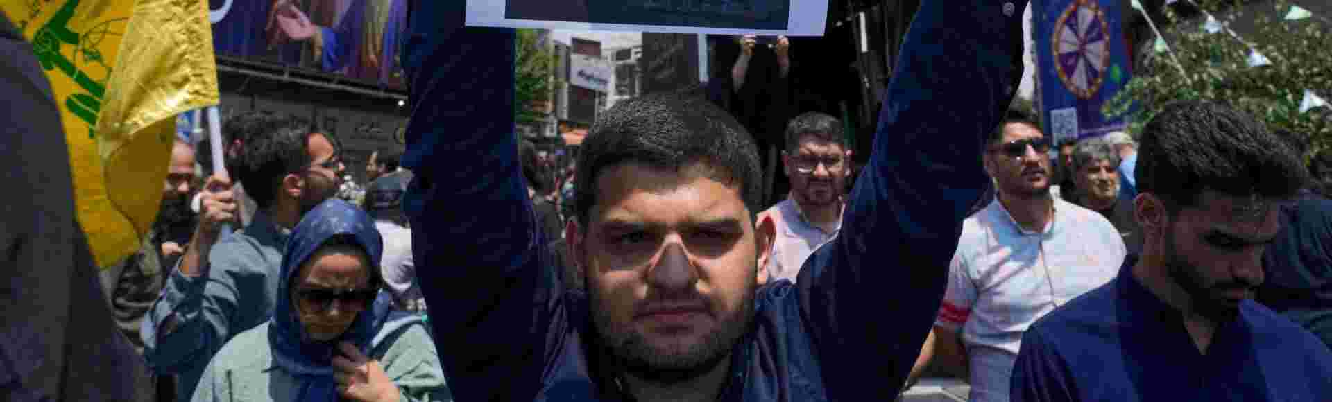 An Iranian protester holds up a poster of Mohammad Bagheri, the chief of Iran's military, who was killed in an Israeli strike.