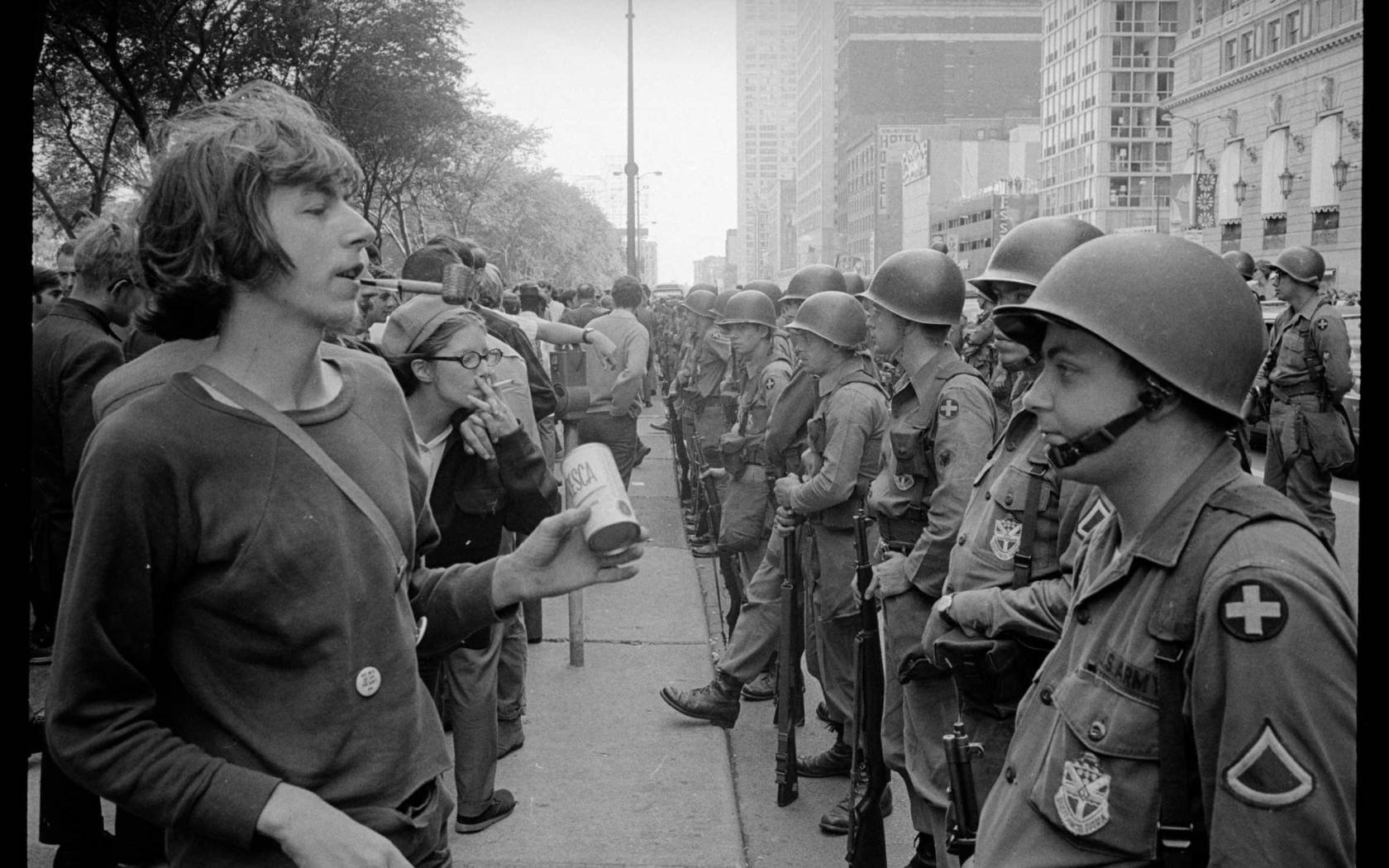 A young 'hippie' stands in front of a row of National Guard soldiers outside the Democratic National Convention in Chicago, on 26 August, 1968.