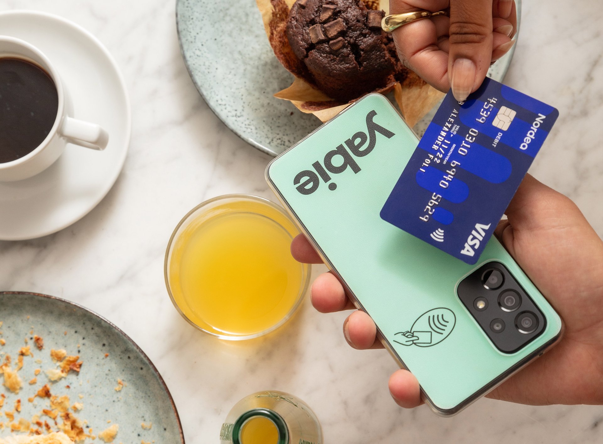 Kund på cafe som betalar med kort på Yabies kassasystem för smartphone