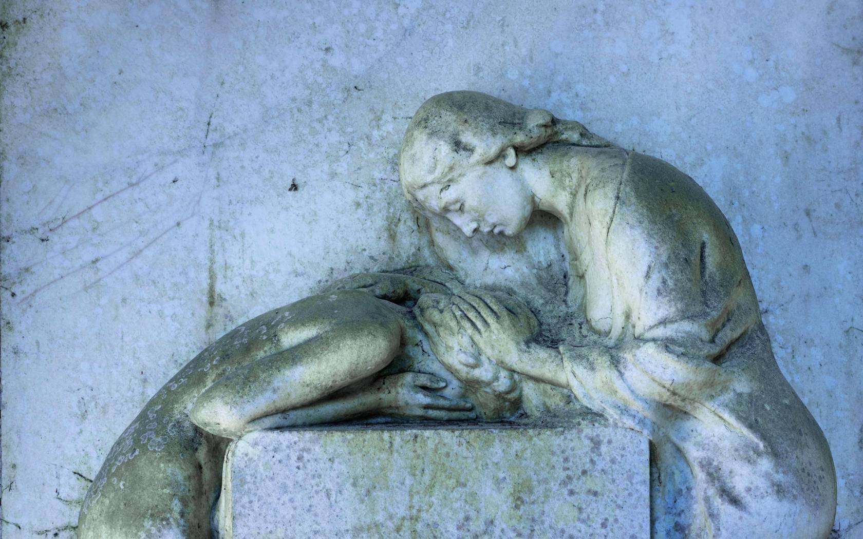 A gravestone with a relief of two mourning female statues at Waldfriedhof, Munich.