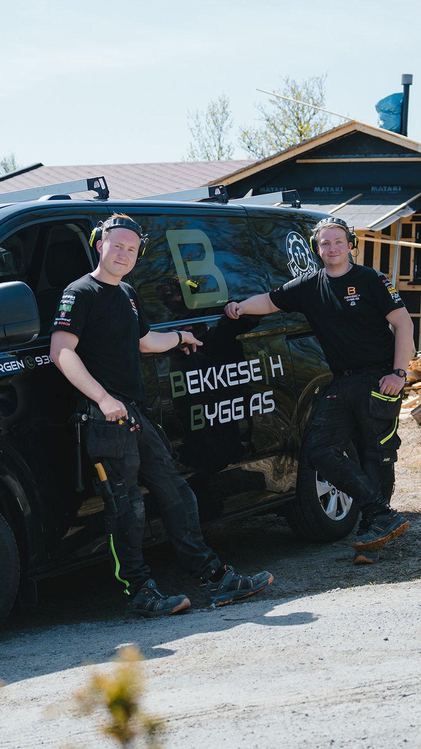 3 tømrere står foran sin arbeidsbil på en byggeplass