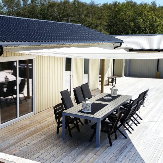 Gult fritidshus med trädäck