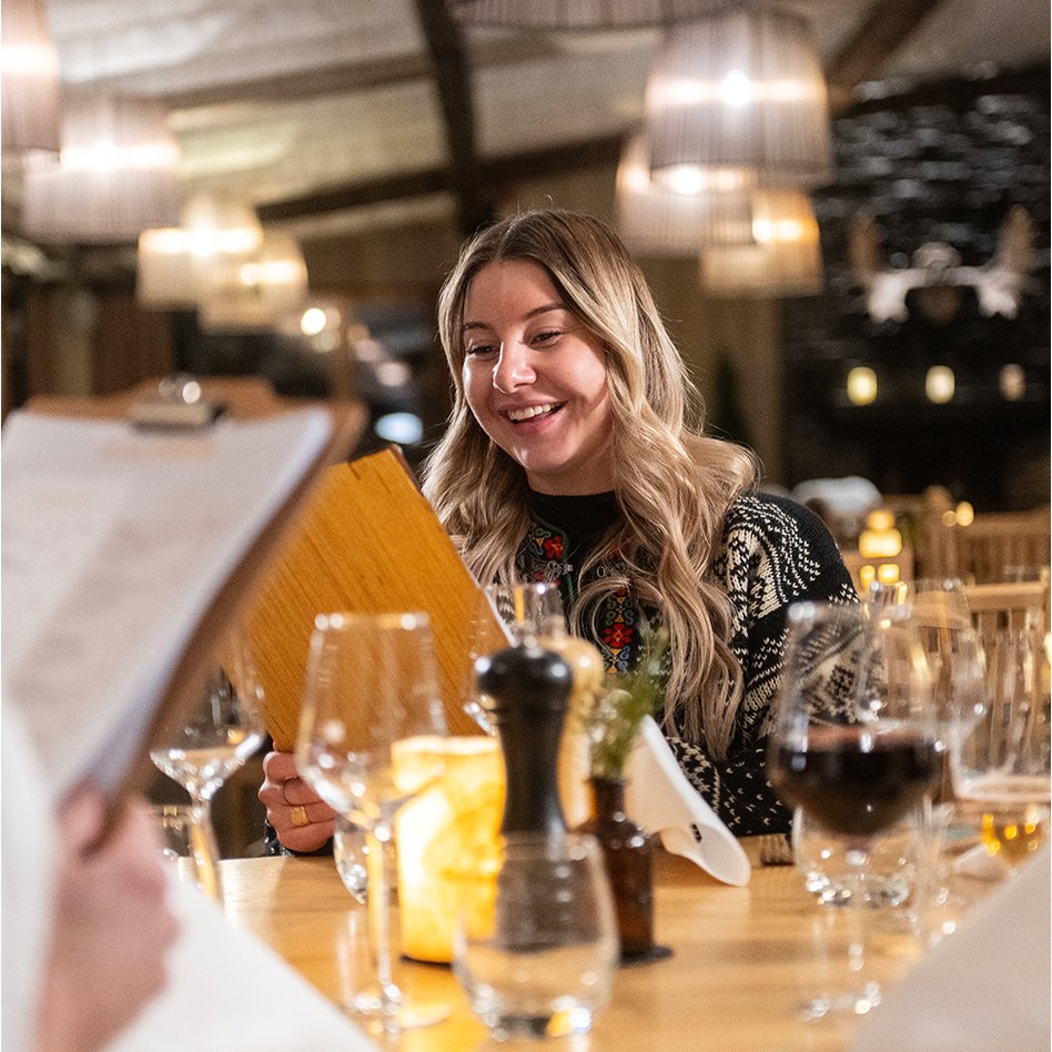 kvinna l&auml;ser meny i Restaurang Lapporten