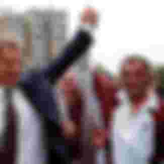 British Prime Minister Tony Blair greets an ethnic Albanian by holding up his hand in central Pristina, Yugoslavia during a one-day visit Saturday July 31, 1999. It was Blair's first visit to Kosovo since NATO's bombing campaign against Yugoslavia. (Photo by David Brauchli)
