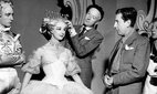 Cecil Beaton adjusting a headpiece backstage.
