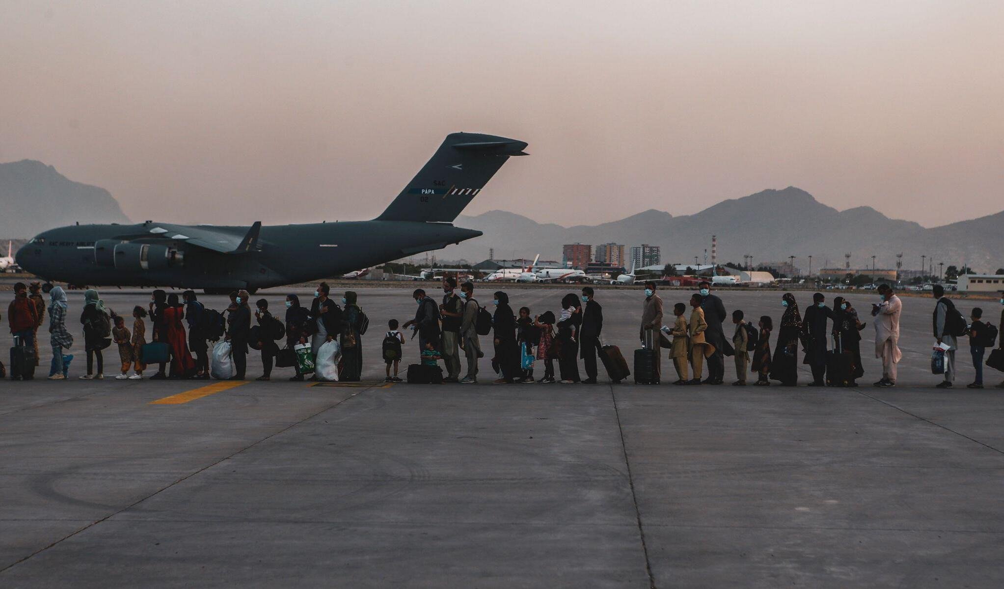 Evacuees wait to board a plane at Hamid Karzai International Airport, Kabul, Afghanistan
