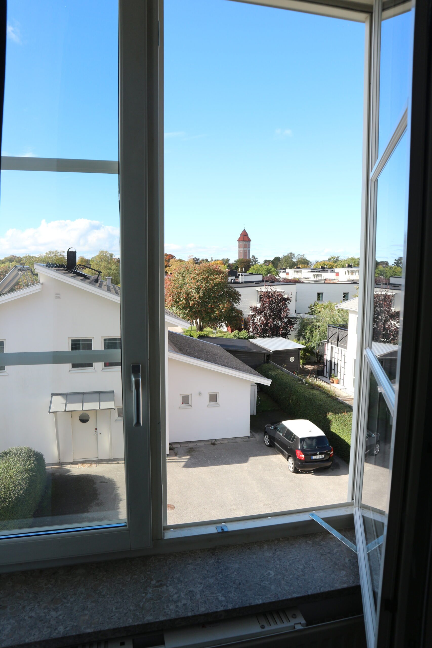 View through window of green residential area.