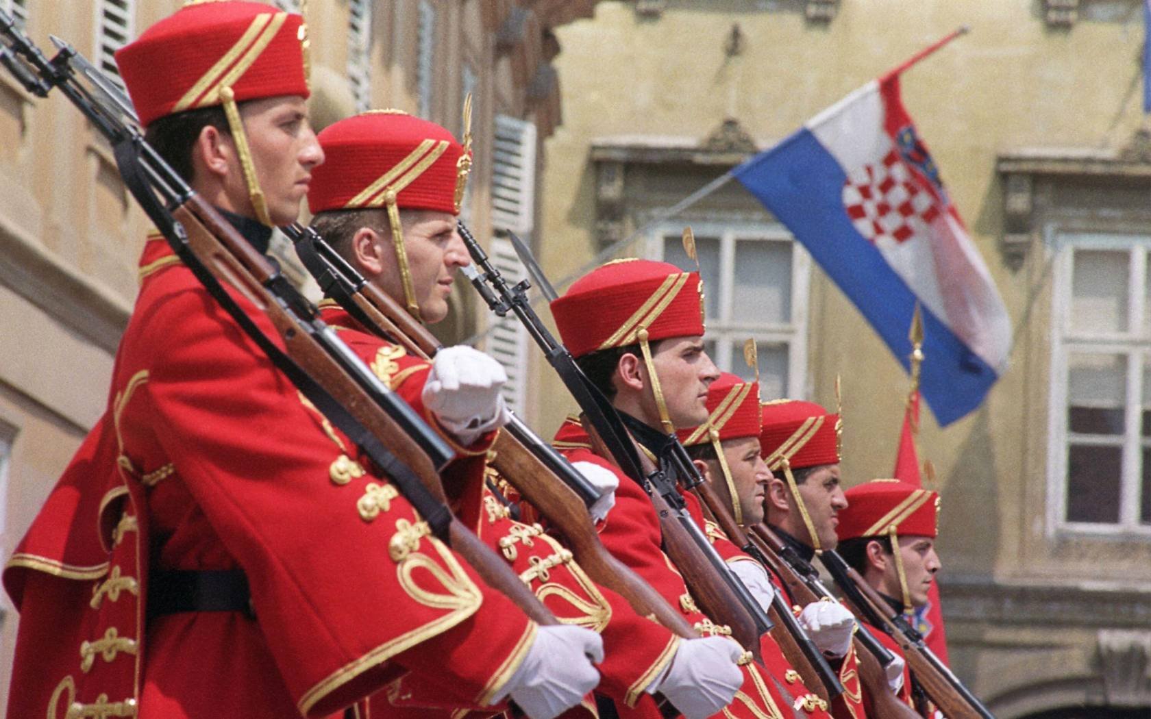 Beneath the Croatian flag members of the guard are lined up during a ceremony in front of the Croatian parliament building in Zagreb, 1991.