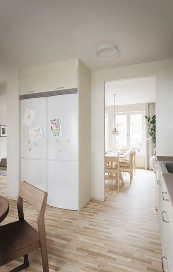 Ett kök med ett bord och ett kylskåp. Hebas hyresradhus i Smedjan i Källberga.