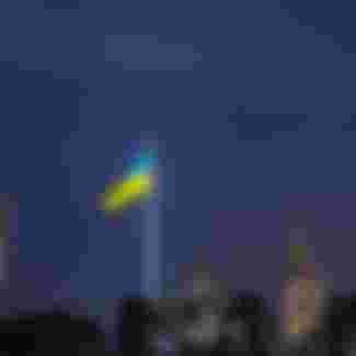 The national flag of Ukraine above the Kyiv skyline.