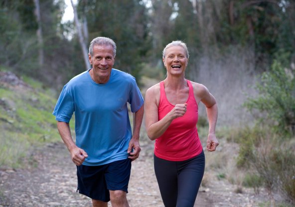 En man och en kvinna är ute och joggar i skogen