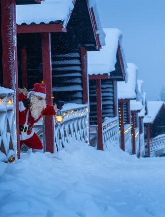 Santa Claus is sneaking around the Kåppa cottage village with a lantern in his hand