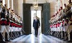 French President Emmanuel Macron walks through the Galerie des Bustes at Versailles.