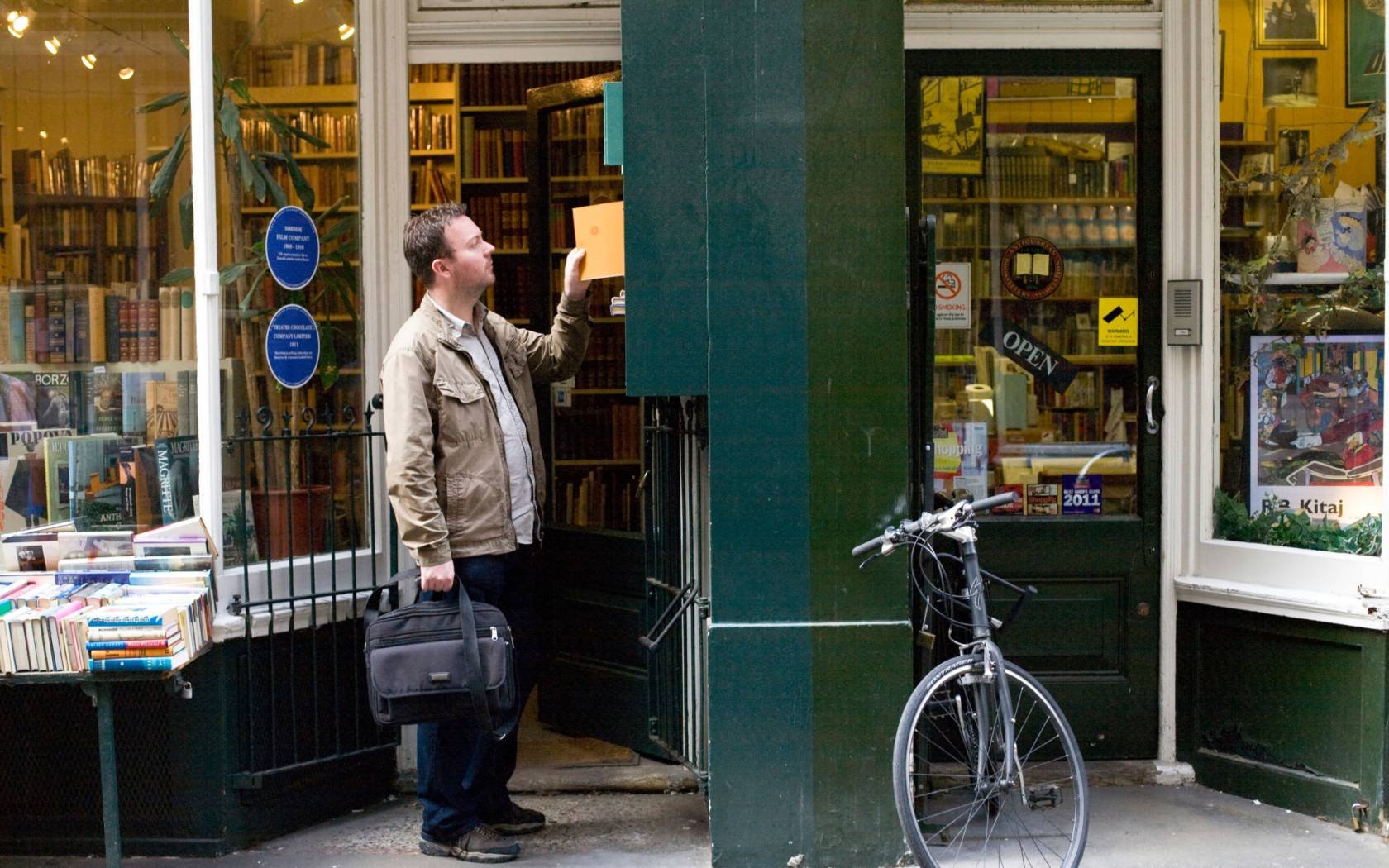 A man searches for a book outside a shop in Cecil Court.