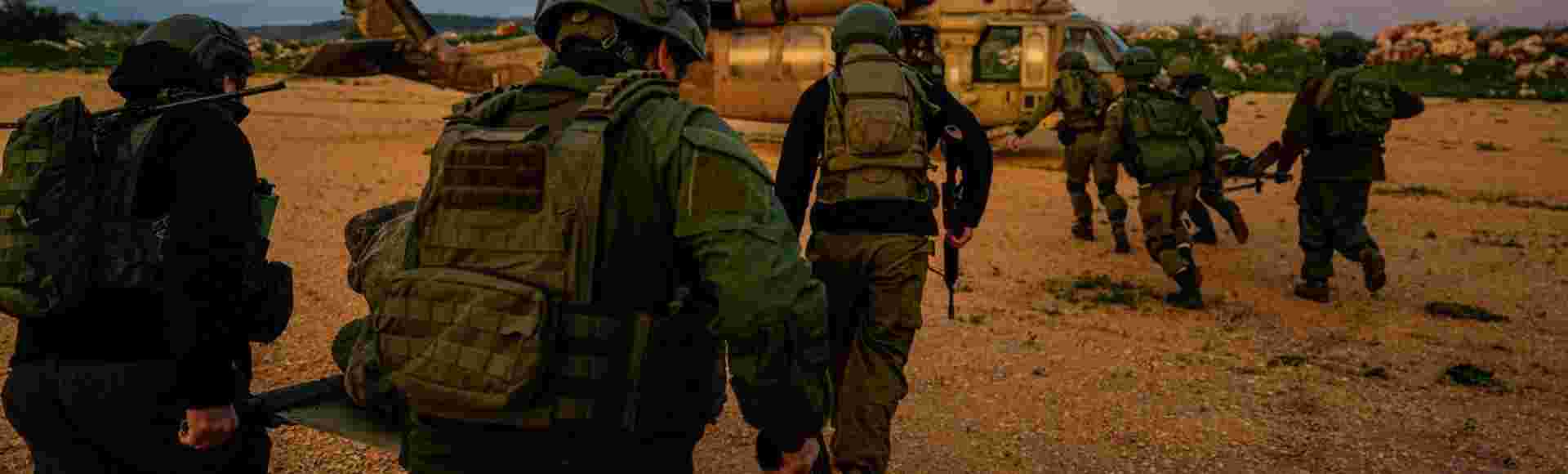 Israeli soldiers run as they carry stretchers towards a military helicopter during an exercise simulating the evacuation of wounded people in northern Israel, near the border with Lebanon in February, 2024.