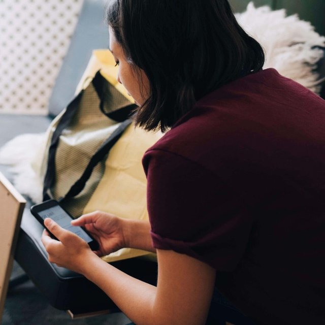 Kvinna som använder mobiltelefon medan hon sitter på en mottagning
