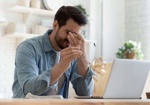 Trött ung man vid dator