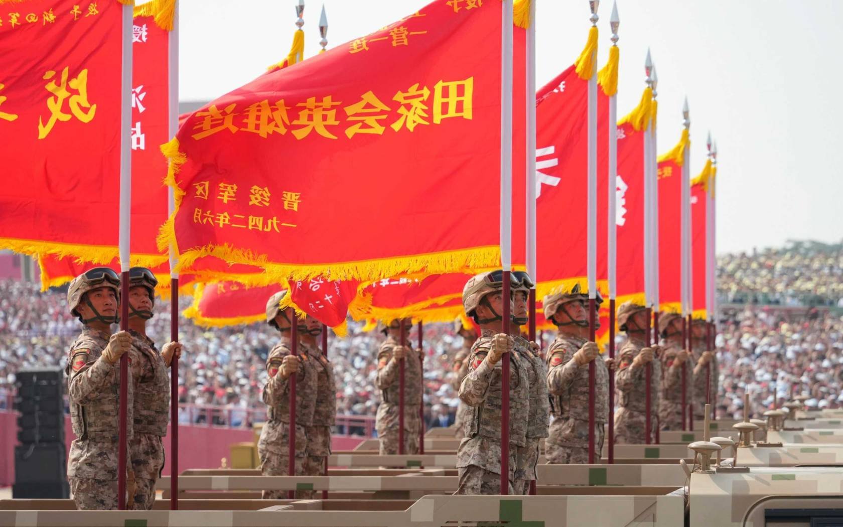 Members of the People's Liberation Army (PLA) holding up flags on trucks during a military parade held in front of Tiananmen Gate on September 3, 2025 in Beijing, China.
