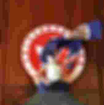 A protester attempts to cover the Hong Kong emblem with a British colonial flag after they broke into the government headquarters in Hong Kong in June 2019, the 22nd anniversary of the city's handover from Britain to China.