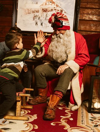 A child high-fives Santa at Gammelgården