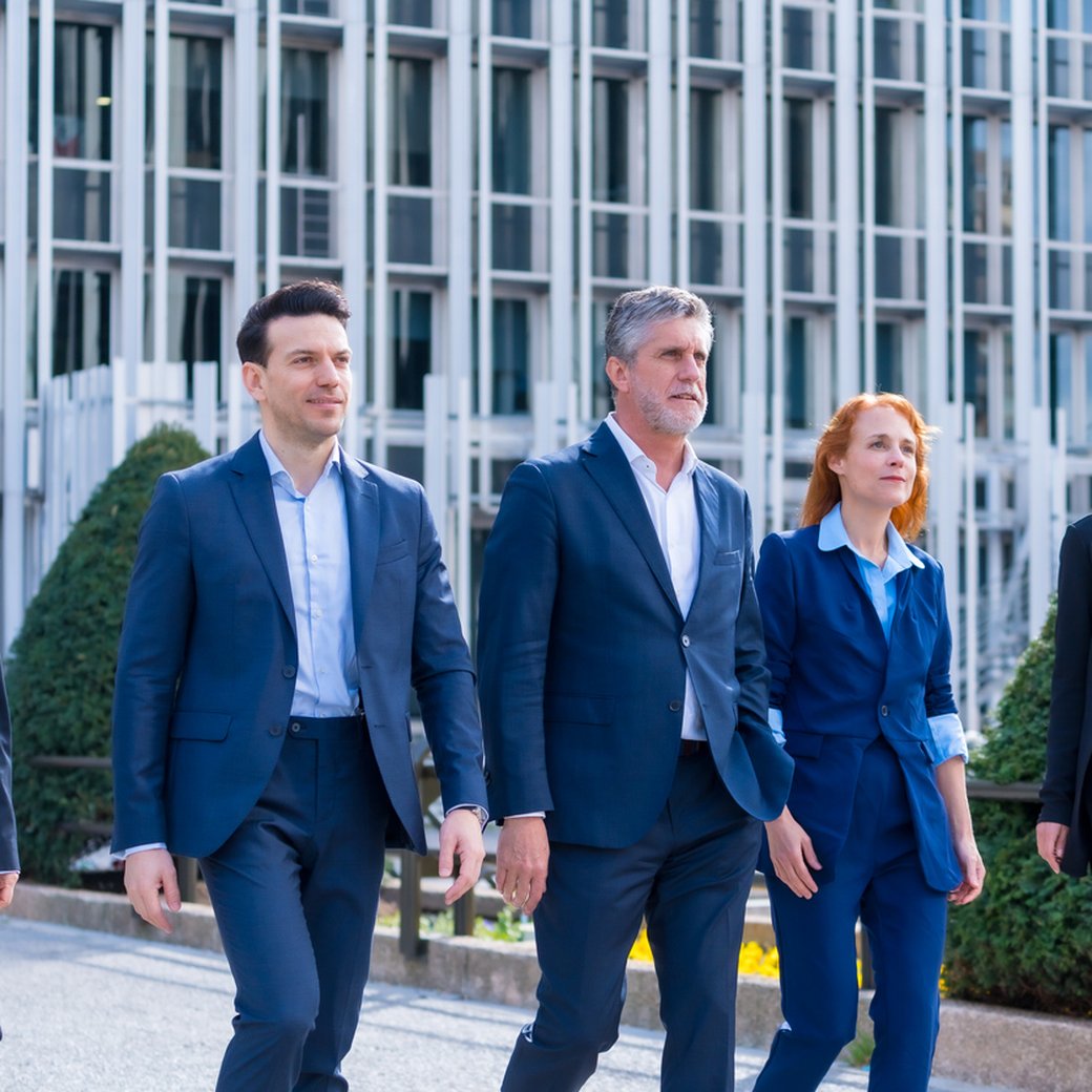 Walking Together: Five Executives Strolling and Chatting in a Commercial Neighborhood