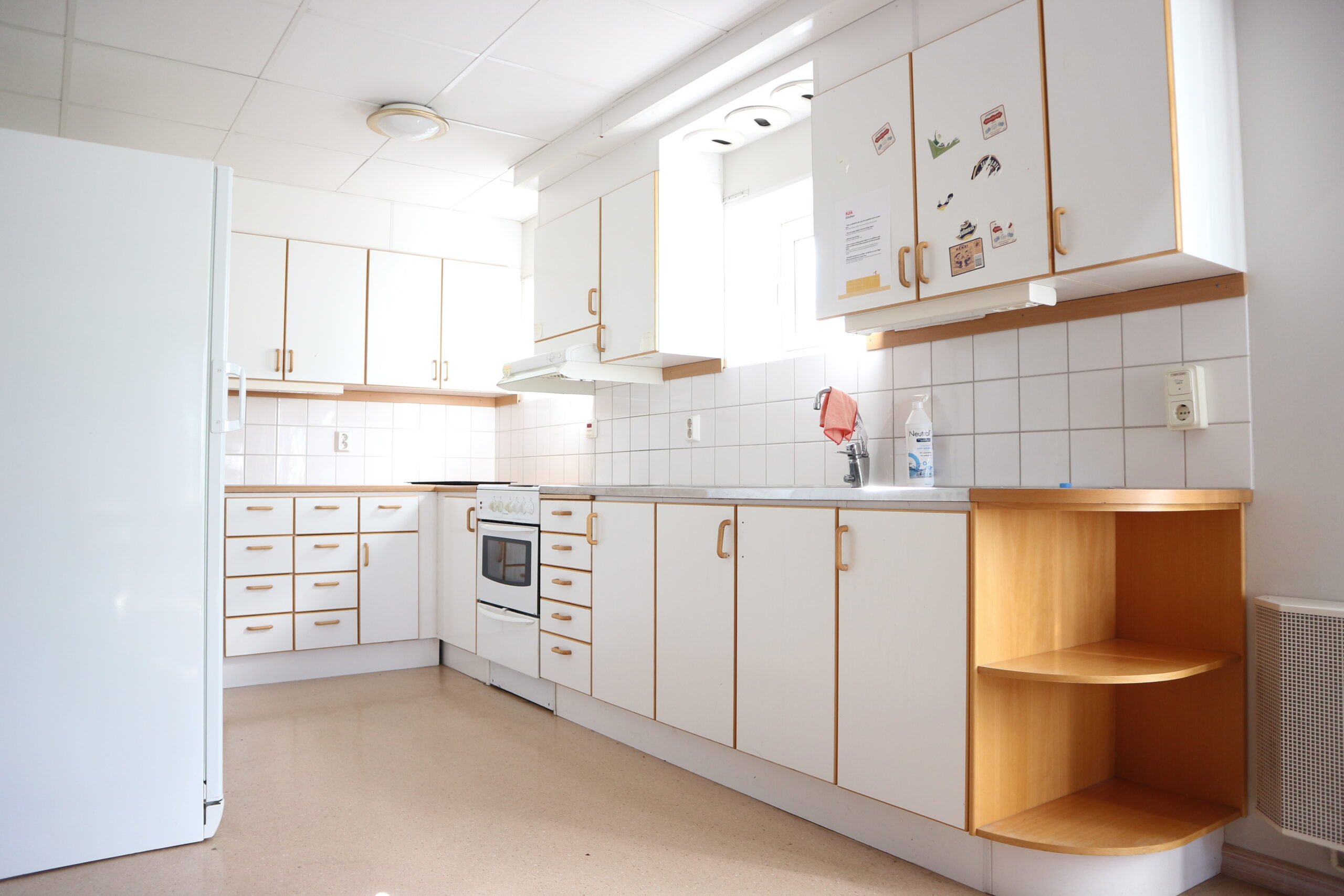 Communal kitchen with cupboards, stove, oven, sink and refrigerator.