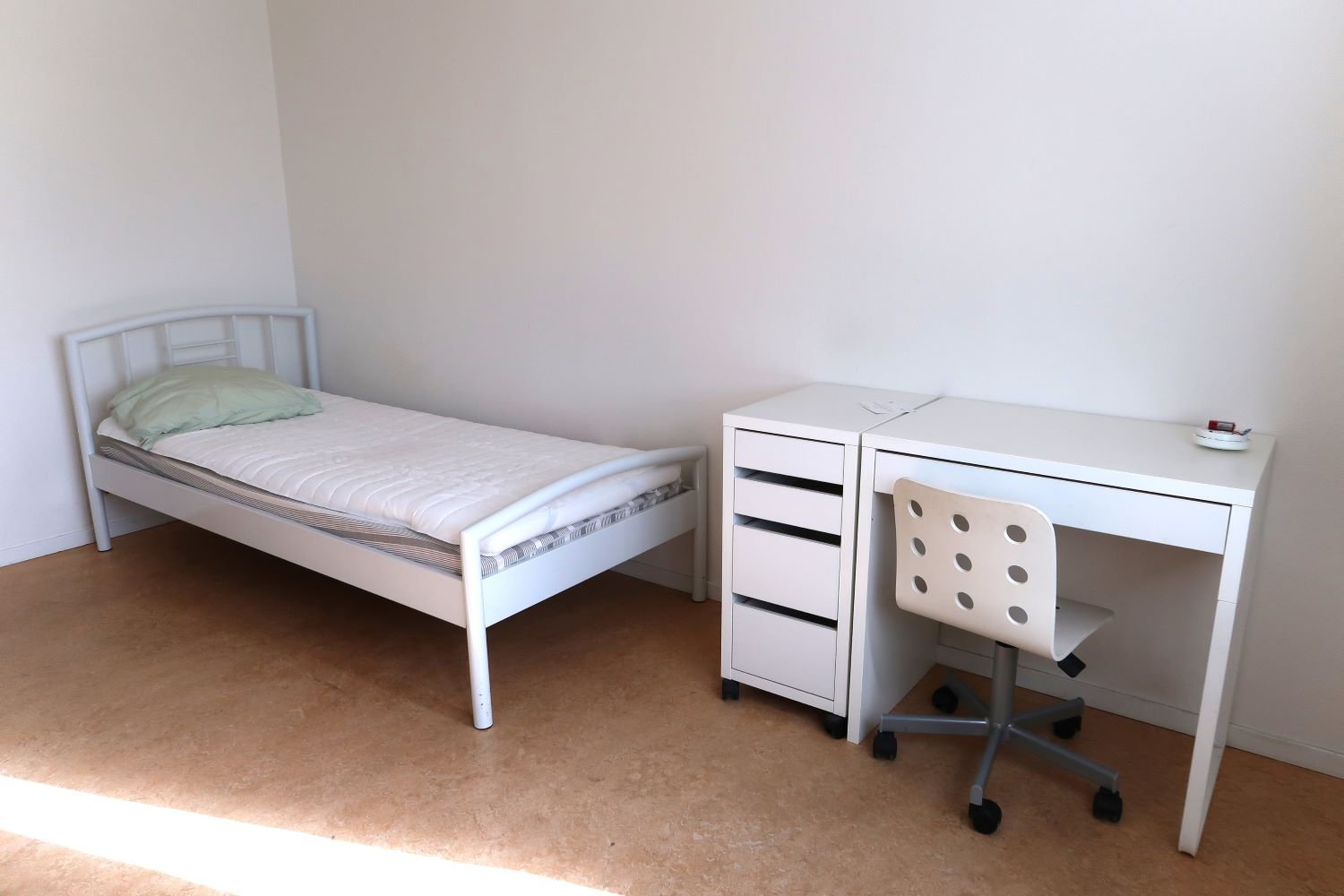 Student room with bed, desk and chair.