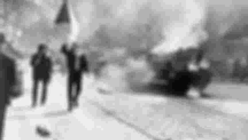 Czechoslovaks carry their national flag past a burning Soviet tank in Prague, 1968. The JIC failed to foresee Soviet retaliations to the mass protests