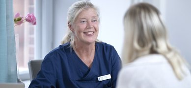 Kvinnlig läkare samtalar med patient