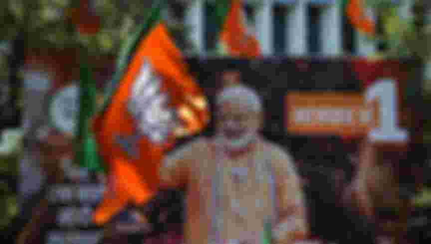 A billboard with an image of Indian Prime Minister Narendra Modi is surrounded by Bharatiya Janata Party (BJP) flags as supporters gather to celebrate election results outside the BJP headquarters in Mumbai in 2019