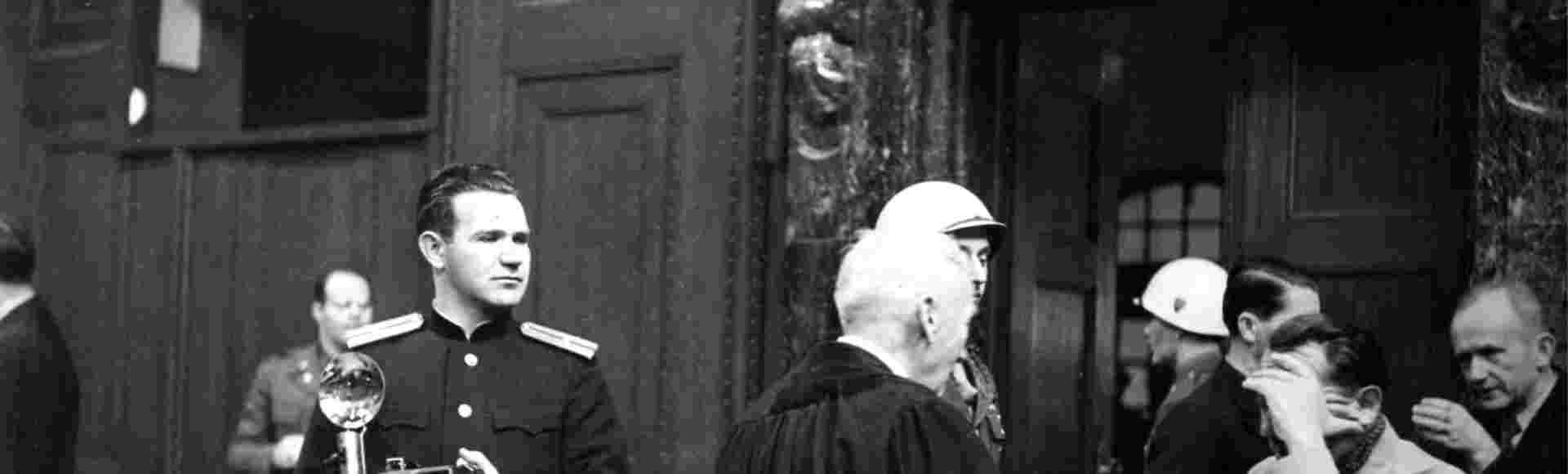Soviet photographer Yevgeny Khaldei in the court room of the Nuremberg Trials while main defendant Hermann Goering covers his face with his hand. Credit: dpa picture alliance